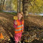 Little girl holding a large leaf