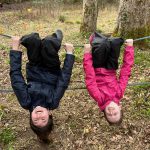 Girls hanging upside down on a rope